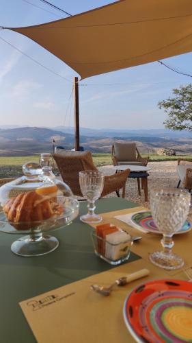 a table with plates of food and glasses on it at Podere Campiano in Volterra