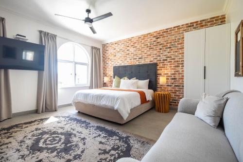 a bedroom with a bed and a brick wall at The Yellow Door Guesthouse in East London