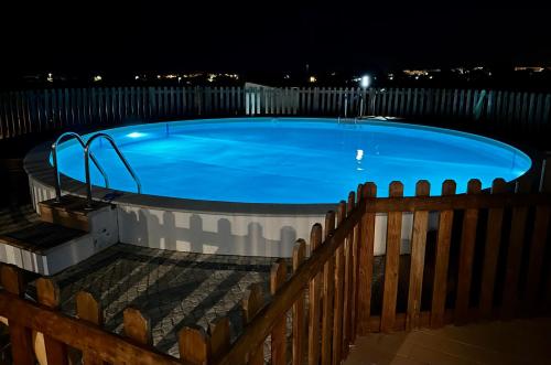 a swimming pool at night with a fence at Quinta da Bornacha - Casa B e Casa C in Vila Nova De Cacela