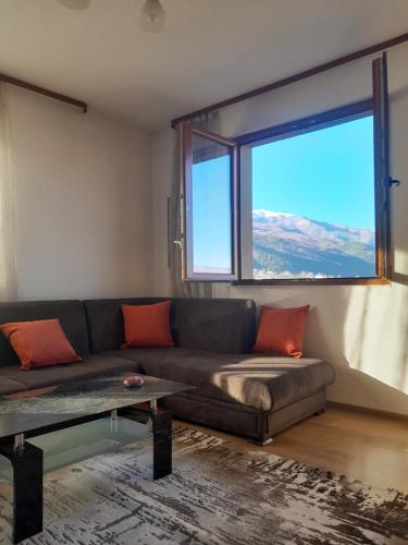 a living room with a couch and a large window at Levkov in Petrich