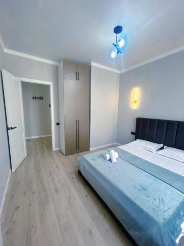 a bedroom with a large bed with a blue blanket at Apart Astana, Комплекс Sat City рядом с Хан-Шатыром in Astana