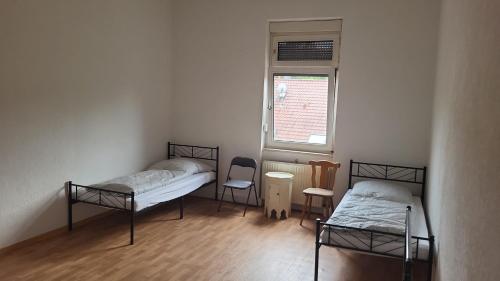 a room with two beds and a window at Graf Kuno Unterkünfte in Bruchsal