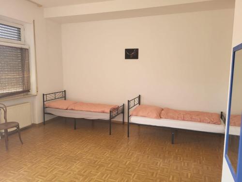 a room with three beds in it with a window at Graf Kuno Unterkünfte in Bruchsal