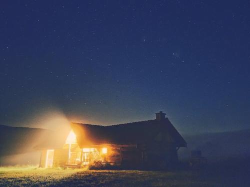 a barn with a light on the side of it at night at Polanka Beskid Niski cute cabin with spectacular views in Hańczowa