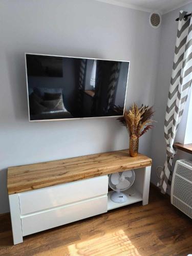 a flat screen tv on a white wall at apartament 30 m2 FOR YOU in Szczawno-Zdrój