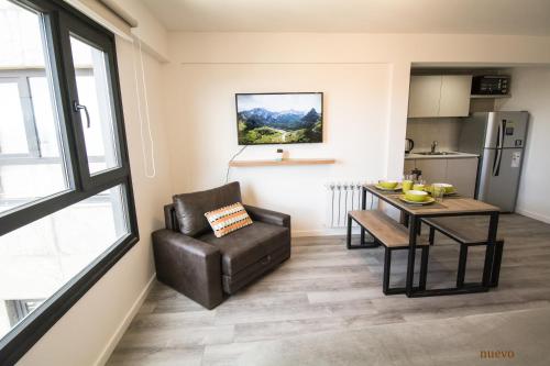 a living room with a table and a chair and a kitchen at Espacio nuevo, tranquilo y céntrico en Bariloche in San Carlos de Bariloche