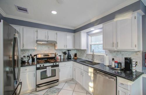 a kitchen with white cabinets and a stove top oven at Your Houston Vacation Getaway 3-BD Pool Patio in Pearland