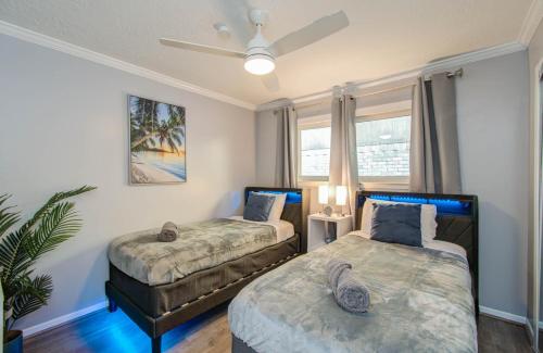 a bedroom with two beds and a ceiling fan at Your Houston Vacation Getaway 3-BD Pool Patio in Pearland