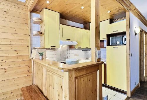 une cuisine avec des armoires jaunes et un comptoir dans l'établissement Résidence Le Bec Rouge - Appartement de charme 3 pièces 8 personnes à Tignes ski aux pieds et proche des commerces dans le quartier du Lac MAE-1993, à Tignes