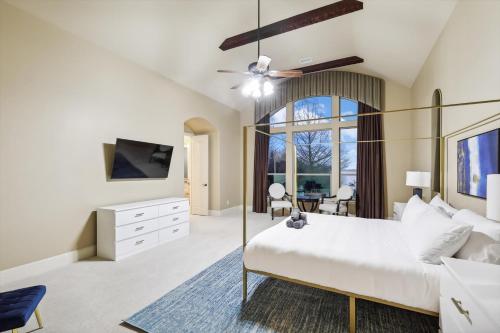 a bedroom with a large bed and a tv at Lakefront Mansion with Pool and Cinema in Rowlett
