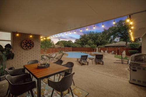 a patio with a table and chairs and a pool at Relaxing Texas Retreat 4BR w Pool & Dream Kitchen in DeSoto