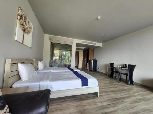 ein Schlafzimmer mit einem großen Bett und einem Schreibtisch in der Unterkunft Veloche Karon in Karon Beach