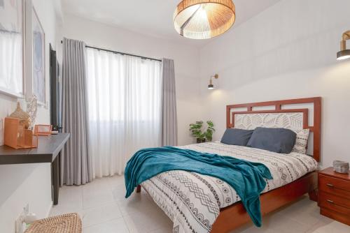 a bedroom with a bed with a blue blanket on it at Zambarau - Luxury Kilifi Coastal Home in Kibarani
