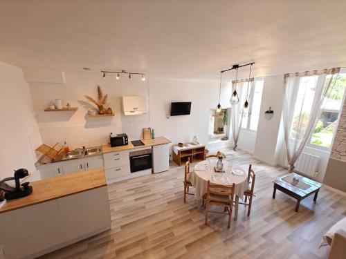 une cuisine et une salle à manger avec une table dans une pièce dans l'établissement Le Duplex du Centre - Idéal pour un séjour détente !, à Saint-Savinien