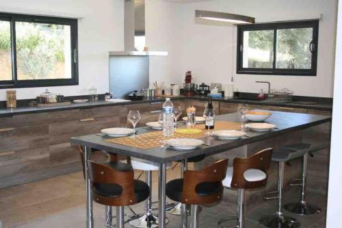 une cuisine avec une table, des chaises et un comptoir dans l'établissement Villa avec vue panoramique mer et montagne, à Portigliolo