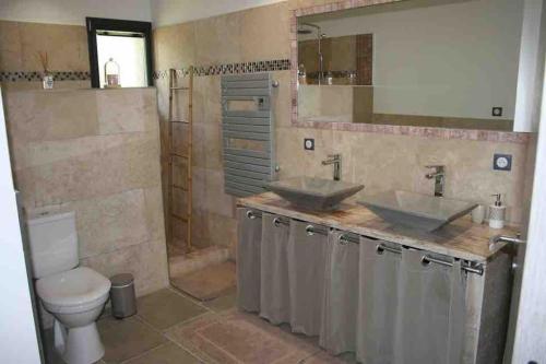 une salle de bain avec deux lavabos et un WC dans l'établissement Villa avec vue panoramique mer et montagne, à Portigliolo