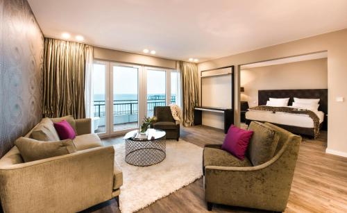 ティメンドルファー・シュトラントにあるStrandhotel Luvのベッドとリビングルームが備わるホテルルームです。