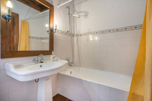 a white bathroom with a sink and a bath tub at Casa de Ansemondes in Refoios do Lima