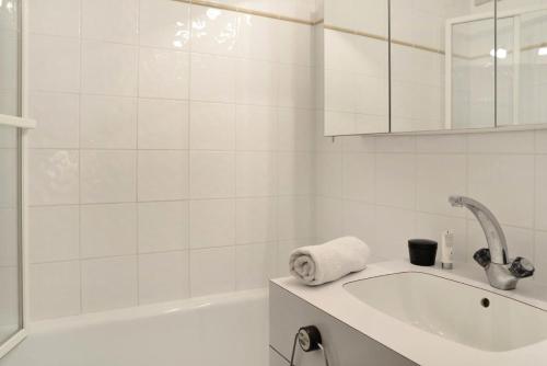 La salle de bains blanche est pourvue d'un lavabo et d'une baignoire. dans l'établissement Residence 3000 - Studio pour 4 Personnes 29, à Mâcot La Plagne