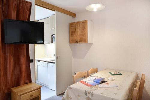 une petite pièce avec une table et une cuisine dans l'établissement Residence 3000 - Studio pour 4 Personnes 29, à Mâcot La Plagne