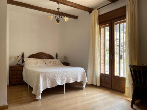 a bedroom with a bed and a large window at Casa Rural Raíces del Alto Tajo in Armallones