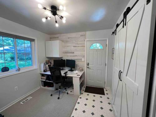 a home office with a desk and a ceiling fan at Cute Home near U of M and EMU in Ypsilanti