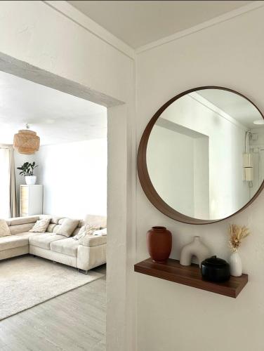 un salon avec un grand miroir au mur dans l'établissement Charmant & Cosy T2 near Airport, à Longjumeau