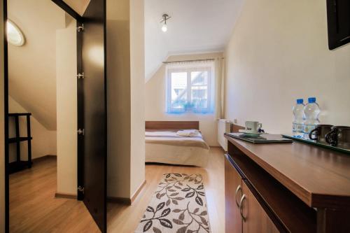 Una pequeña habitación con una cama y una cocina. en Pensjonat Arnika, en Zakopane
