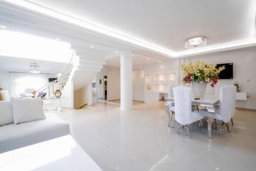 a white living room with a table and white chairs at SP Private Holidays in Anavissos