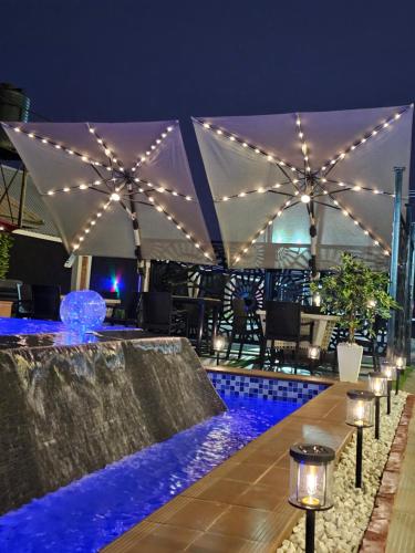 a swimming pool at night with lights on a tent at 2 Bed Apartment 6 - Chic Benin City Hideaway in Benin City