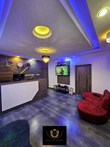 a living room with a red couch and a flat screen tv at 2 Bed Apartment 8 - Modern Benin City Residence in Benin City