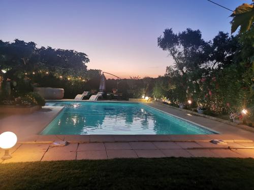 une piscine dans un jardin la nuit dans l'établissement le jardin de mae, à Bouc-Bel-Air