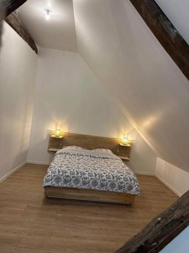 une chambre avec un lit dans un grenier dans l'établissement Chez TH'Auxonne, à Auxonne