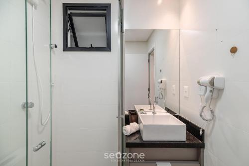 a bathroom with a sink and a mirror at MHF II - Apts Variados em Prédio com Vista para o Mar em Itapema in Itapema