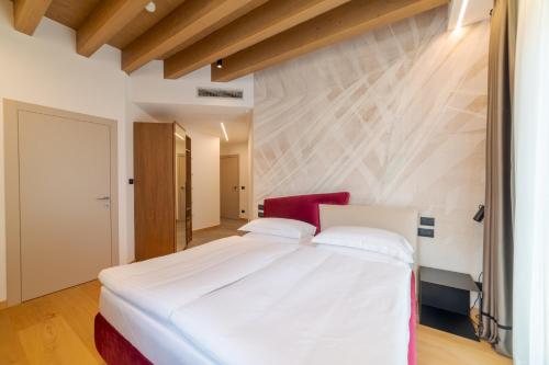 a bedroom with a large white bed in a room at Wine Hotel Ristorante San Carlo - Boutique Hotel & SPA in Chiuro