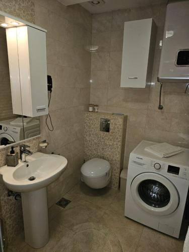 a bathroom with a sink and a washing machine at AS Apartment in Podgorica