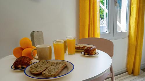 une table avec des assiettes de nourriture et deux verres de jus d'orange dans l'établissement Le Petit Cocon de Carcassonne, à Carcassone