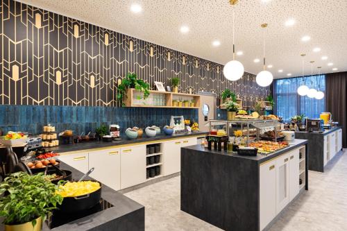a large kitchen with a bunch of food on display at Holiday Inn - the niu, Flower Konstanz by IHG in Konstanz