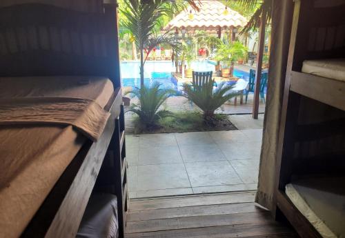 a room with a view of a pool and a bed at Hostal Hilltop Palomino in Palomino
