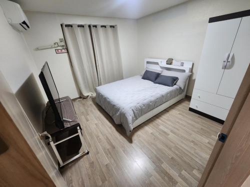 a small bedroom with a bed and a television at 3 bedroom apartments in Incheon