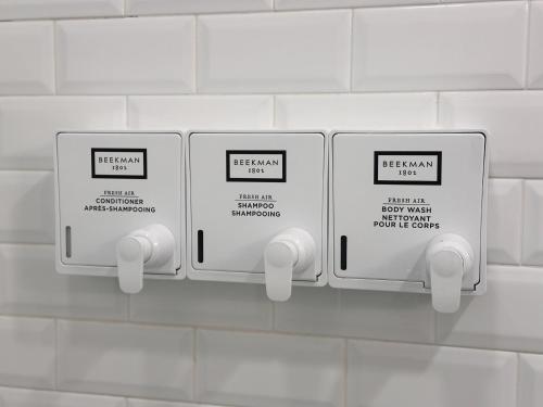two electrical outlets on a white tiled wall at Sosuite at The Vine - Old City in Philadelphia