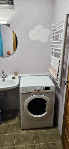 une salle de bain avec une machine à laver et un lavabo dans l'établissement Résidence Les Arolles - Studio cabine 4 personnes 2 exposé Sud MAE-7081, à Valloire