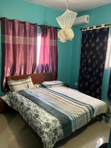 a bed sitting in a room with a window at Maison de vacances in Mbour