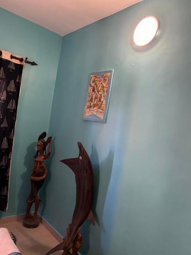 a room with a blue wall with a fish sculpture on the wall at Maison de vacances in Mbour