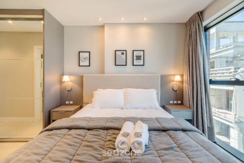 a bedroom with a bed with two slippers on it at MHF II - Apts Variados em Prédio com Vista para o Mar em Itapema in Itapema