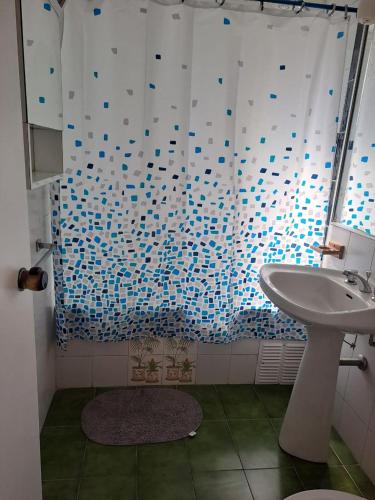 a bathroom with a sink and a shower with blue tiles at Reñaca Gran terraza con vista al mar in Viña del Mar