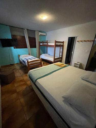 a bedroom with two beds and two chairs in it at Regiane Beach Pousada Hostel in João Pessoa