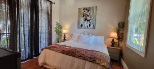 Caye Caulker Boutique Guesthouse 7 في كاي كولكر: غرفة نوم بسرير مع شراشف بيضاء ومصباحين