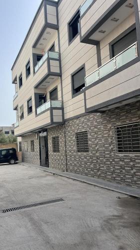 un edificio con un'auto parcheggiata di fronte di Je loue mon appartement, neuf, proche mer a Martil a Martil
