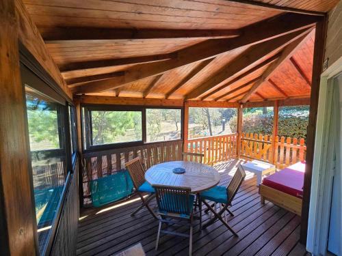un porche en bois avec une table et des chaises dans l'établissement Cap d Agde hébergement 6 personnes avec piscine, à Agde